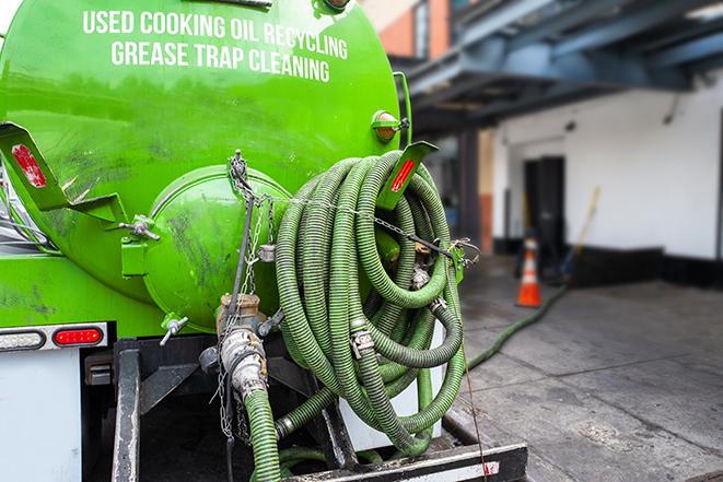 worker pumping grease trap at commercial kitchen in Gonzales TX